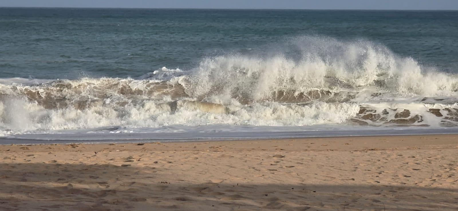 Een golf die breekt op het strand