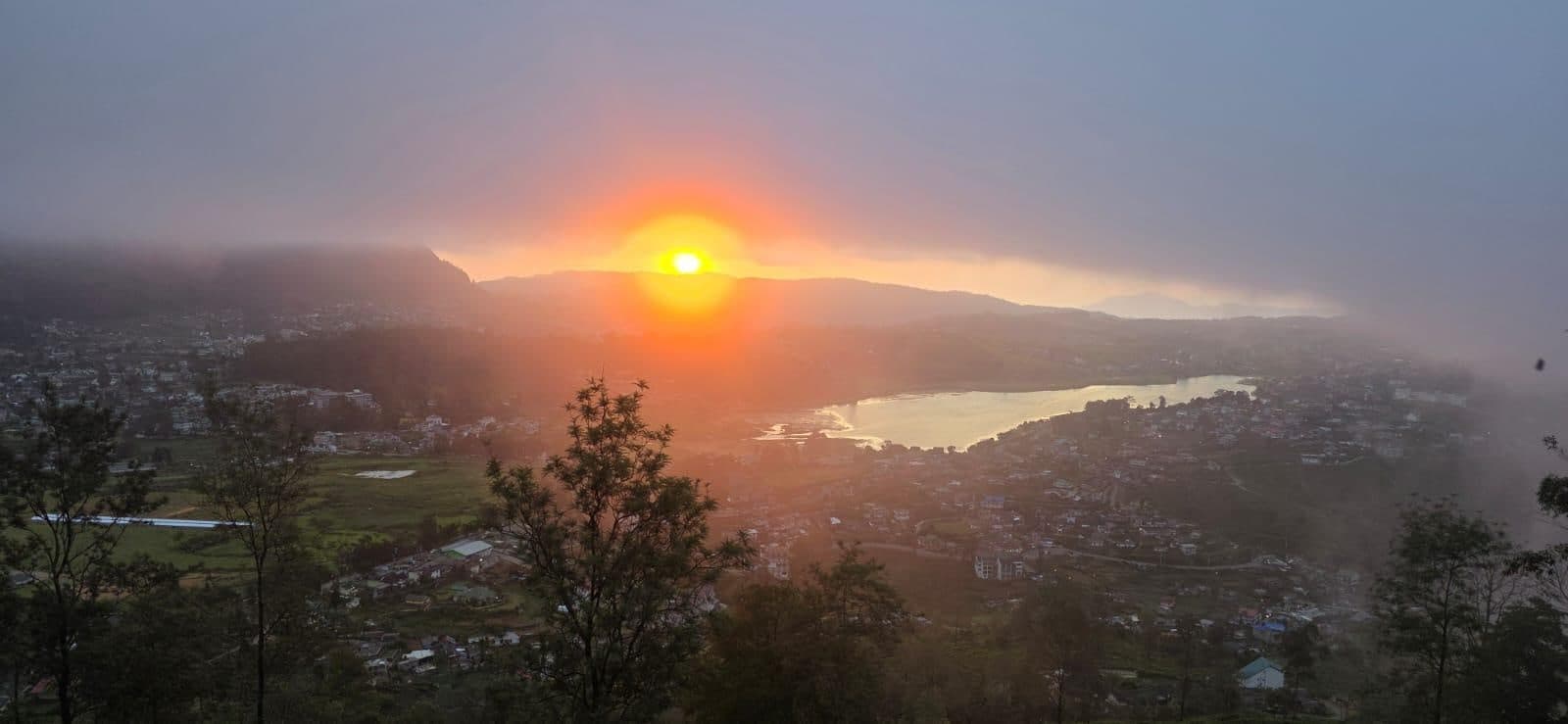 De zon komt op boven een dal met een meer